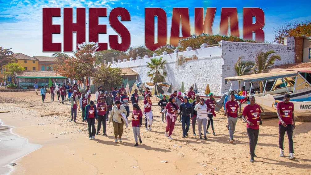 Photographie de personnes marchant sur une plage, texte en grand "EHES DAKAR".