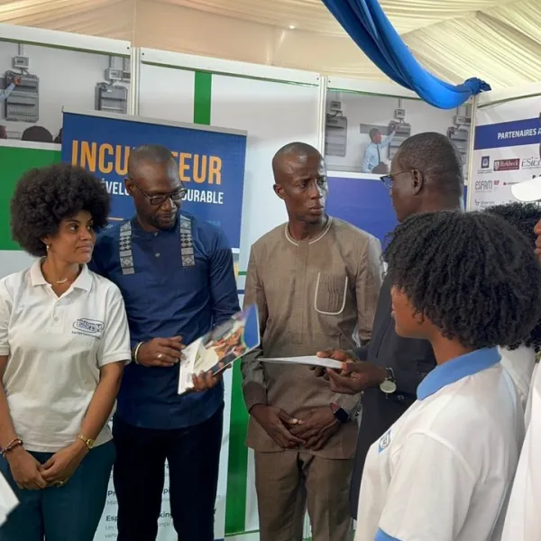 Personnes discutant dans un stand d'exposition.