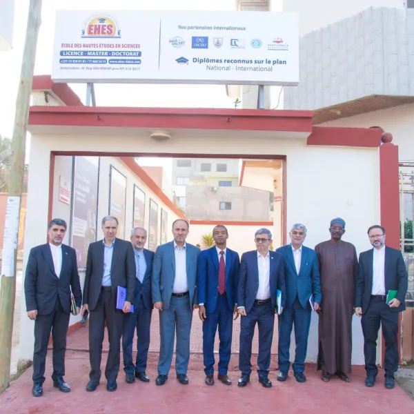 Dix hommes en costume devant un b&acirc;timent avec enseignes.